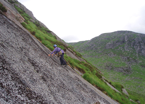 Linda Biggar about to reach the border on the first ascent of the Road to Wrath, Dungeon Hill Crags in the background.